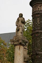 Frau versorgt Bettler, Statue auf Nebensäule zur Nagelsäule.